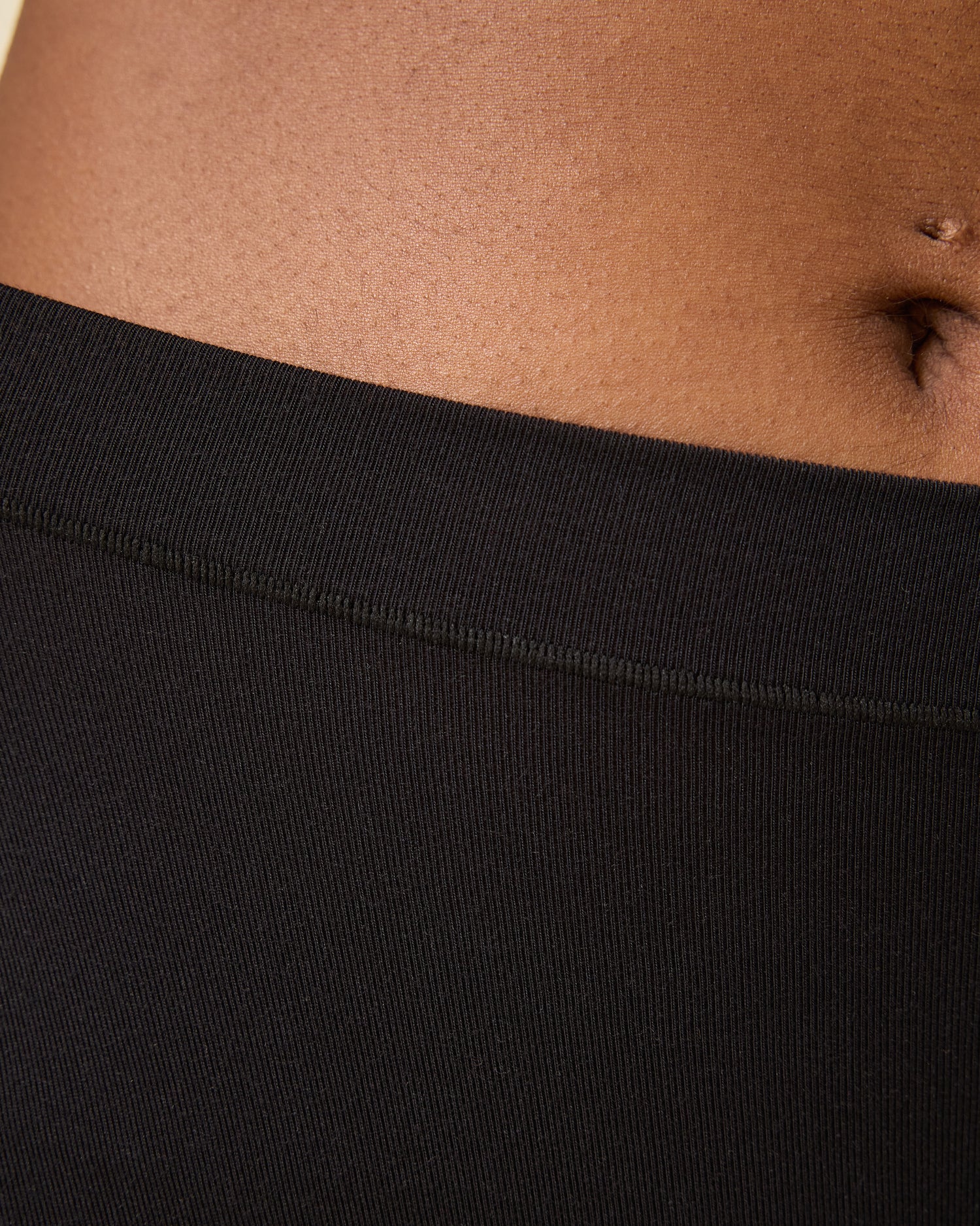 Close up of Every Stage Brief in Black on a beige background 