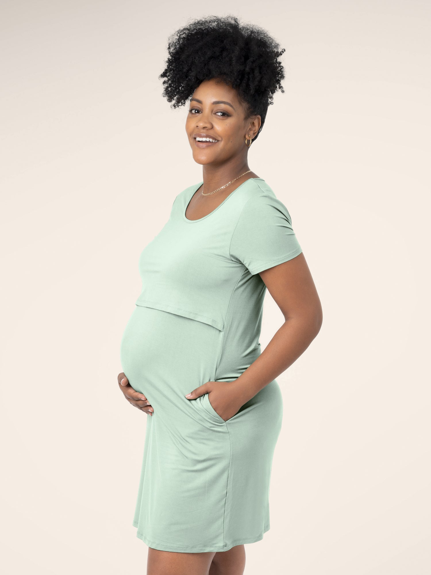 Side view of model wearing the Eleanora Bamboo Maternity & Nursing Dress in soft mint, with hand in pocket