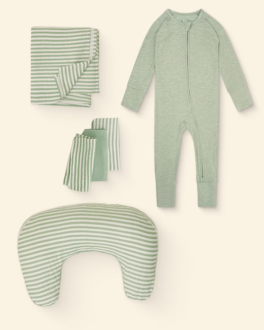 Set of green and white stripe patterned nursing pillow, burp cloths, swaddle and baby onesie on a light background