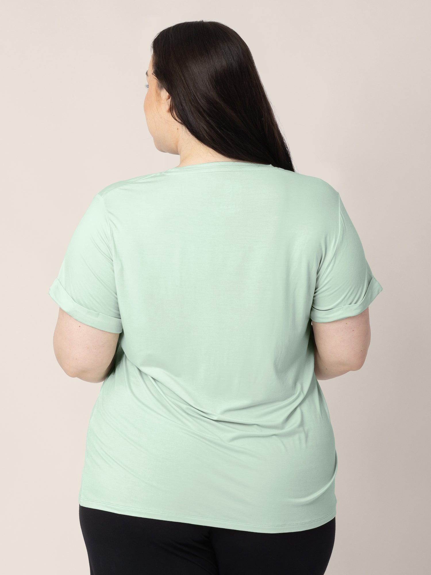 The back of a model wearing the Everyday Asymmetrical Nursing T-shirt in Soft Mint.