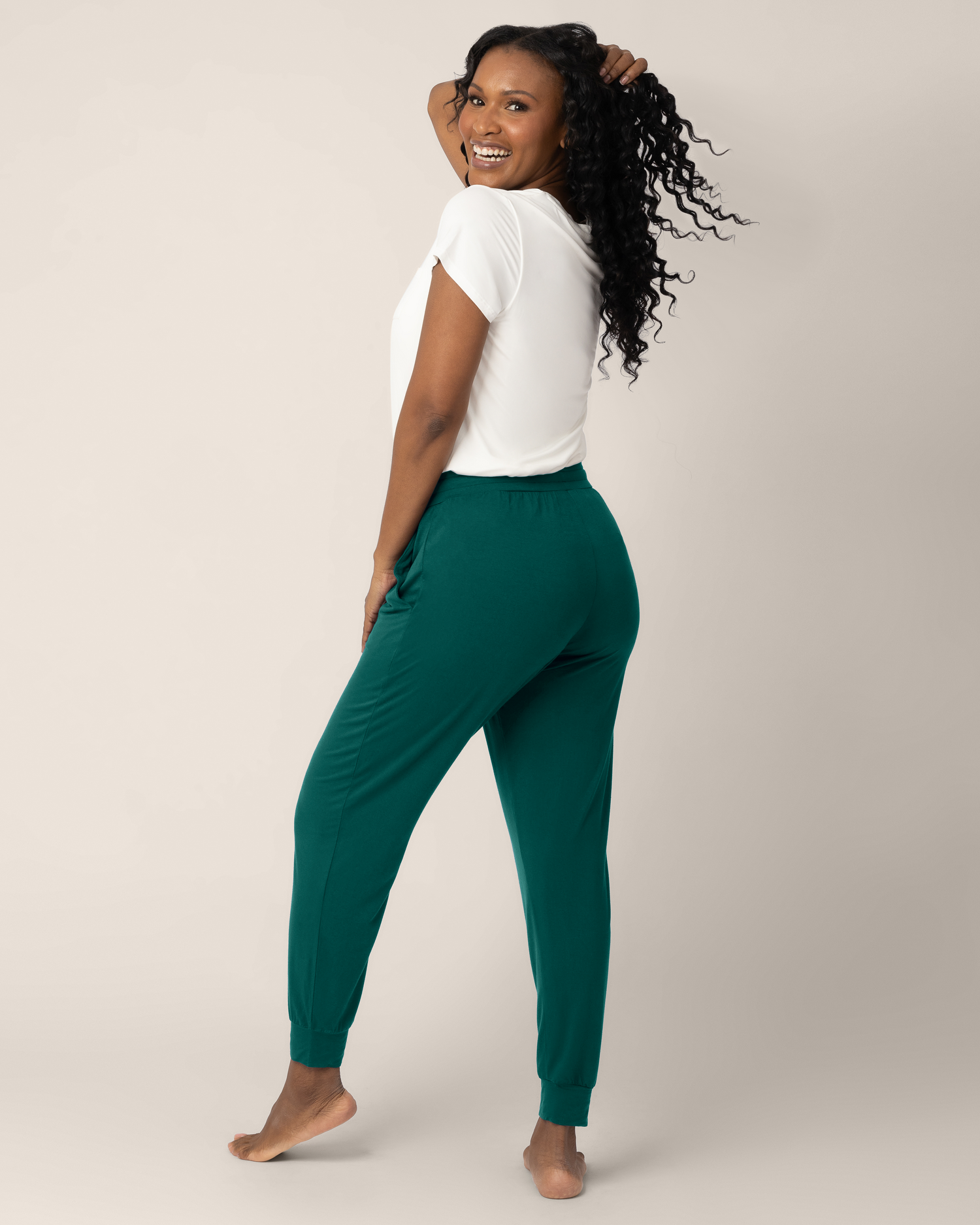 3/4 back view of model wearing the Everyday Lounge Jogger in Evergreen, paired with the Everyday Maternity & Nursing T-shirt in White