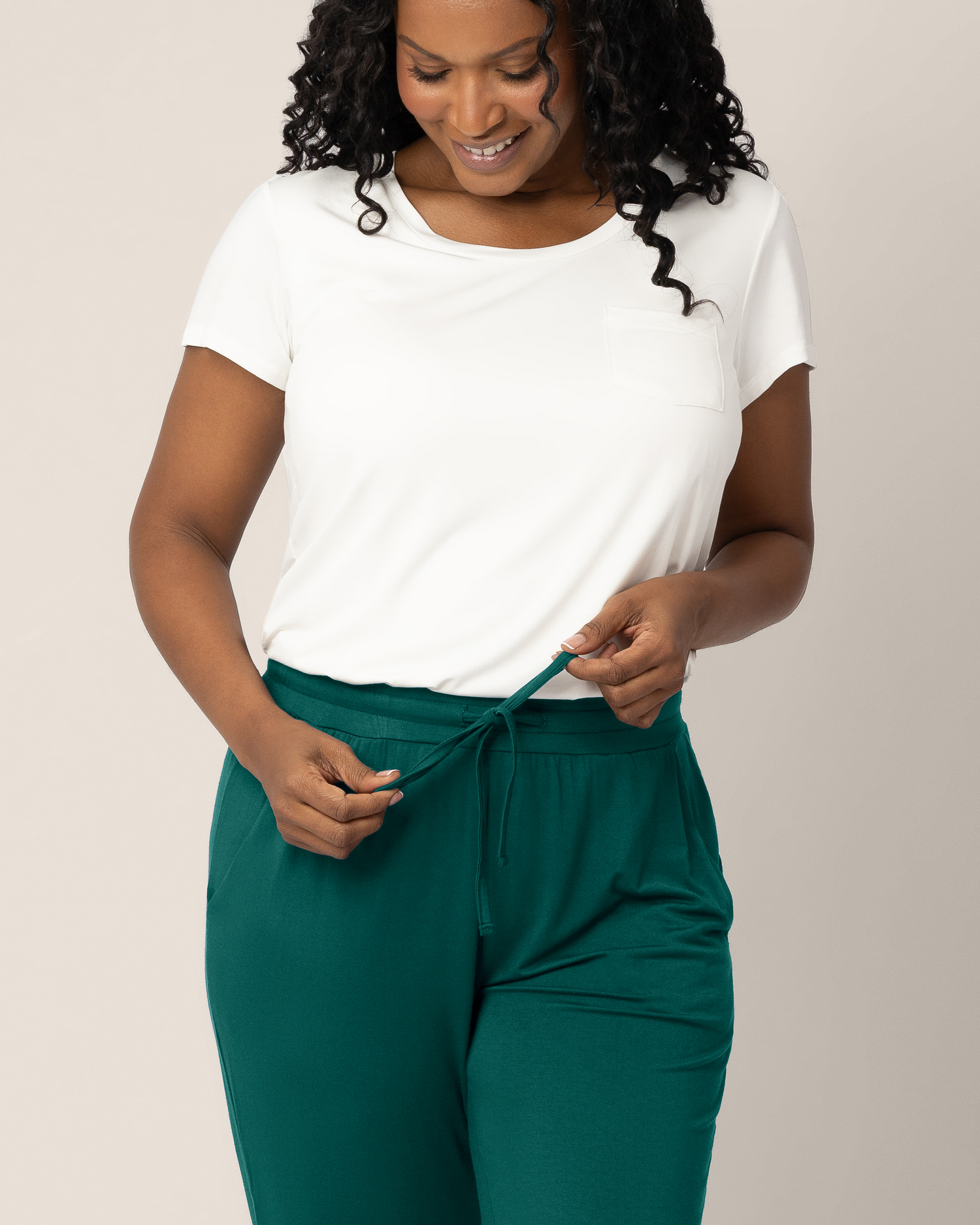 Close up of model wearing the Everyday Lounge Jogger in Evergreen highlighting drawstring, paired with the Everyday Maternity & Nursing T-shirt in White