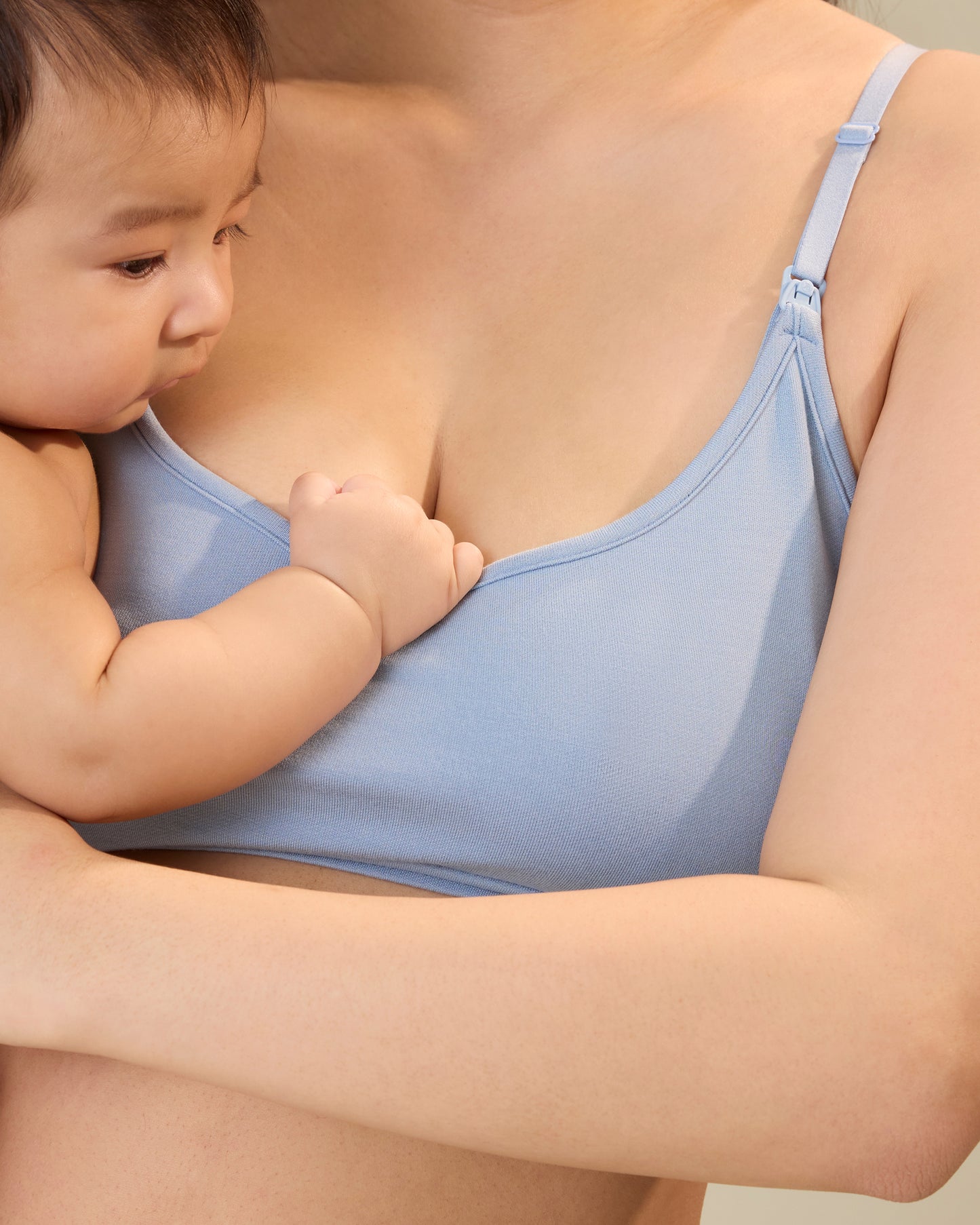 Close up of model holding a baby and wearing French Terry Maternity & Nursing Bralette in Vintage Blue@model_info:Cassie is wearing a Medium.