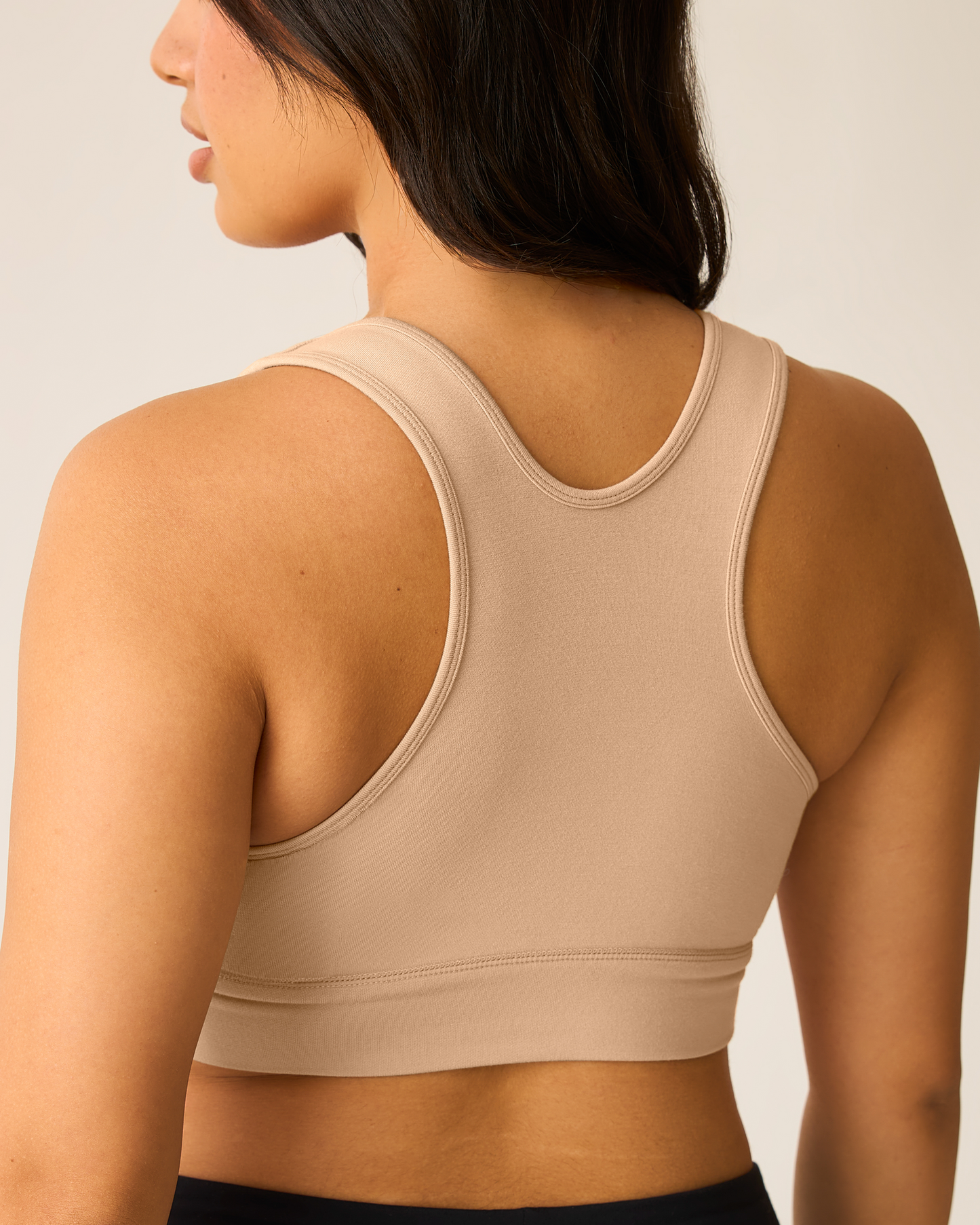 French Terry Racerback Nursing & Sleep Bra in beige worn by a woman on a plain background, showing racerback