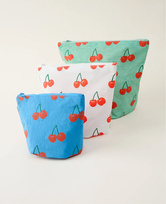 Three zipper pouches with cherry pattern on a beige background