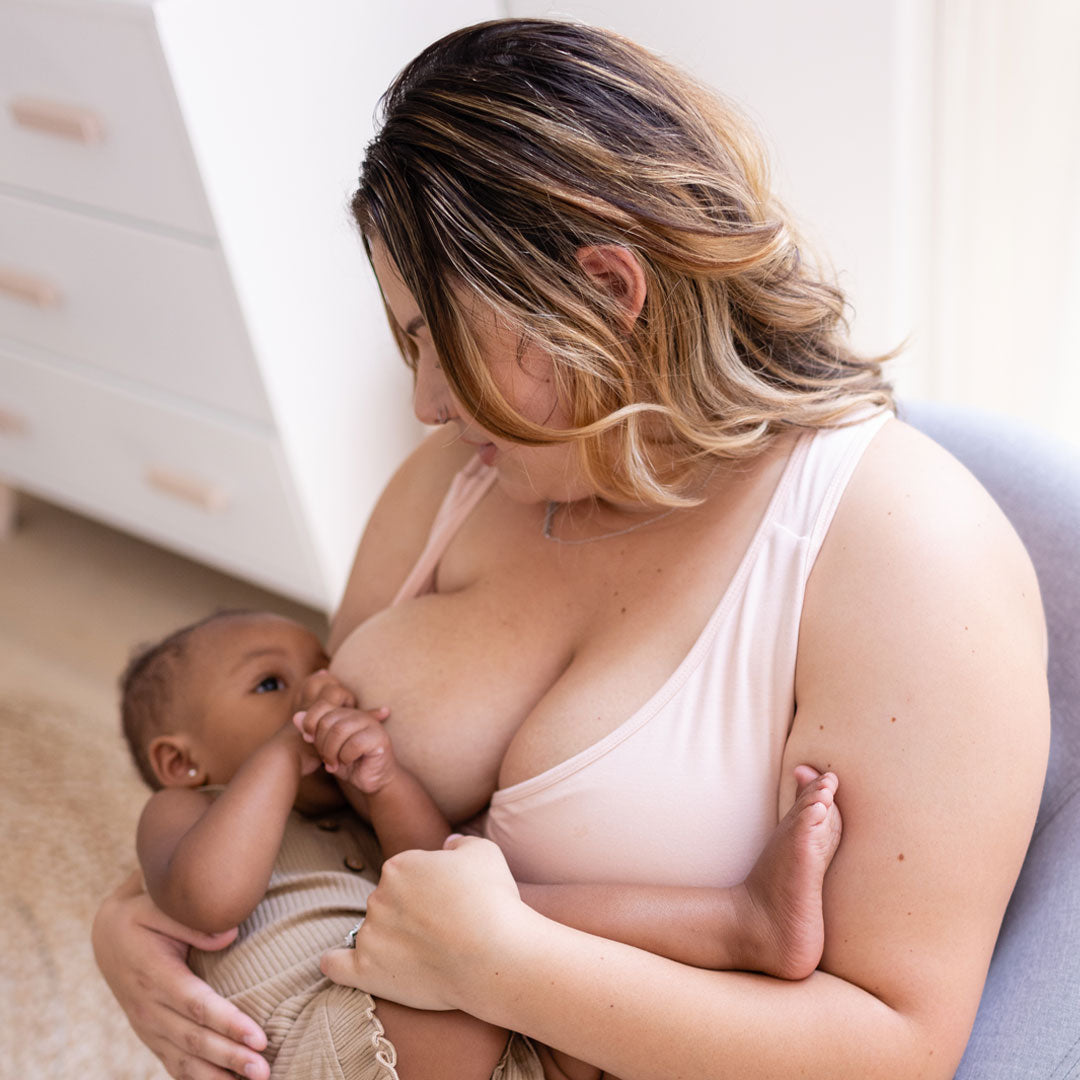 Model breastfeeding her baby while wearing the French Terry Racerback Nursing & Sleep Bra in Soft Pink @model_info:Brianna is wearing a 1X Busty.