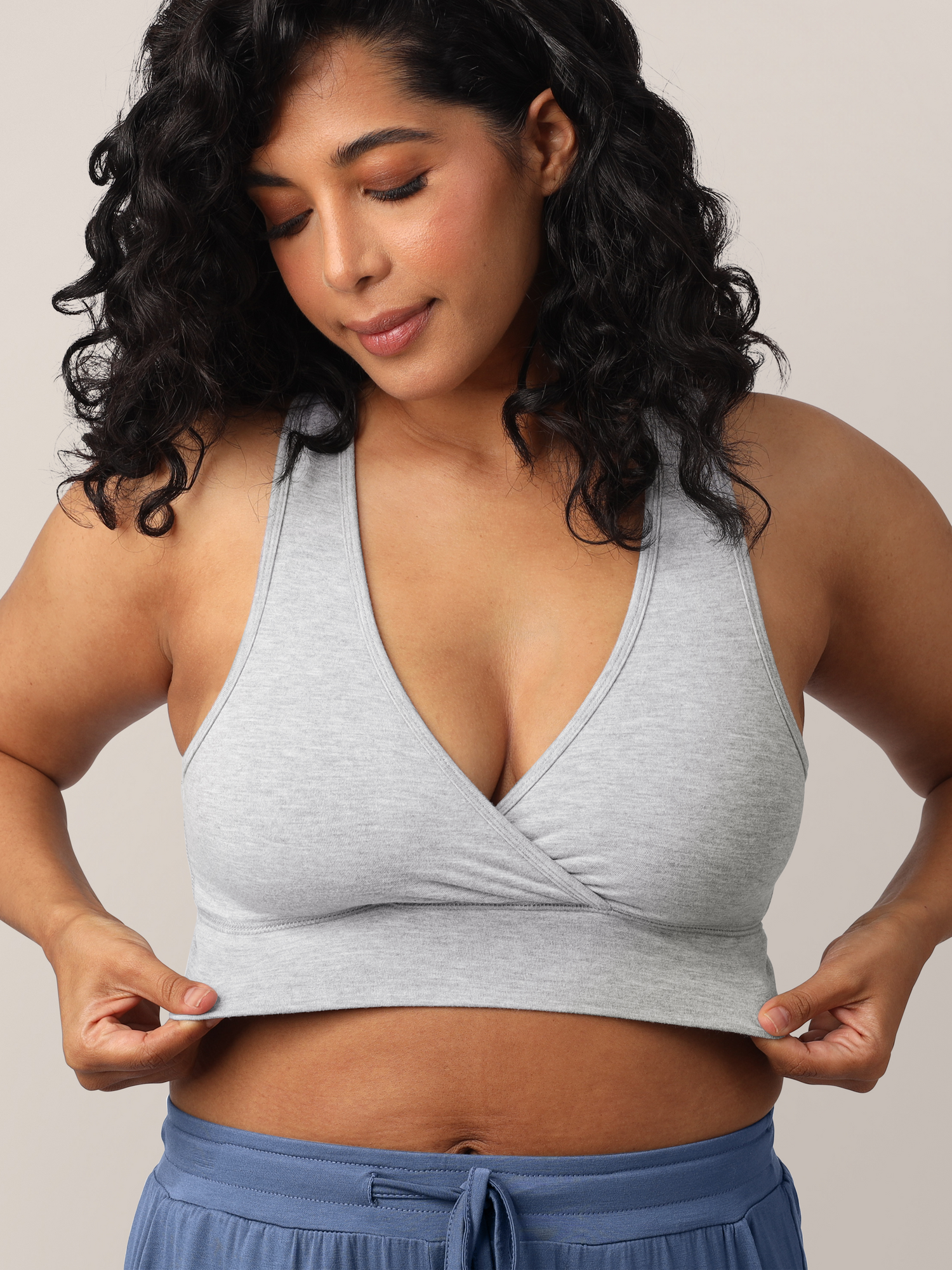 Close up of model wearing the French Terry Racerback Nursing & Sleep Bra in grey heather, showing stretch of fabric