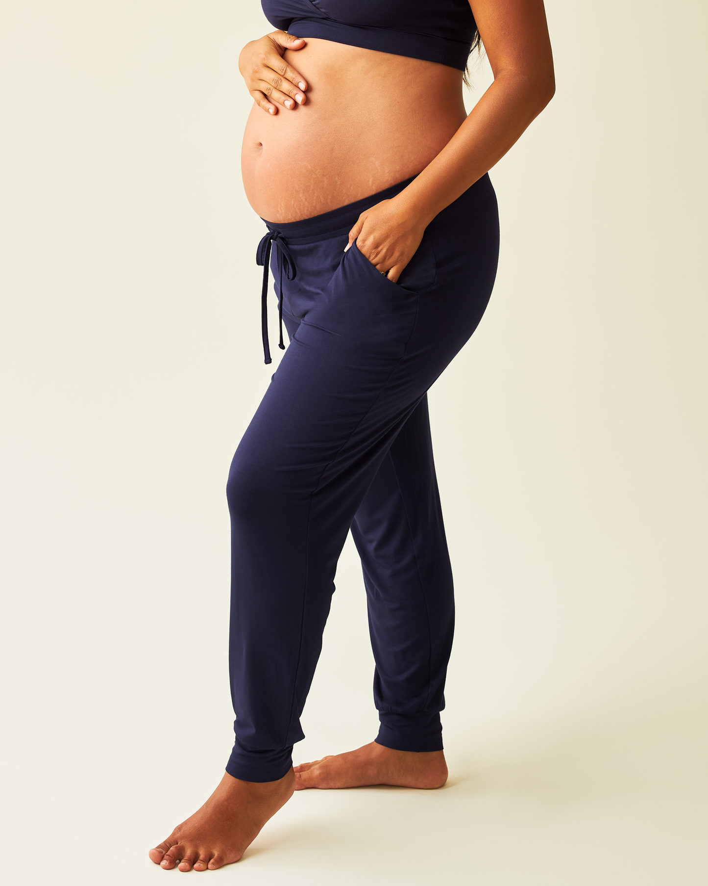 Pregnant person wearing Pregnant model wearing the Everyday Lounge Jogger in Navy on a light background