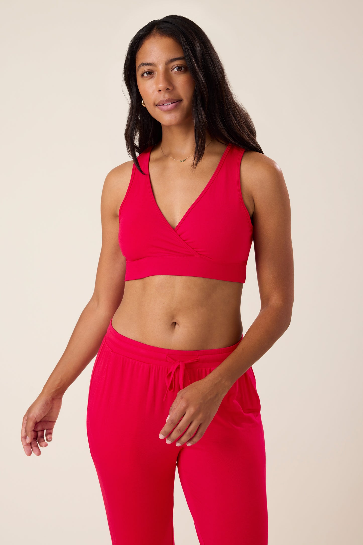 Model wearing French Terry Racerback Nursing & Sleep Bra in Red on a beige background
