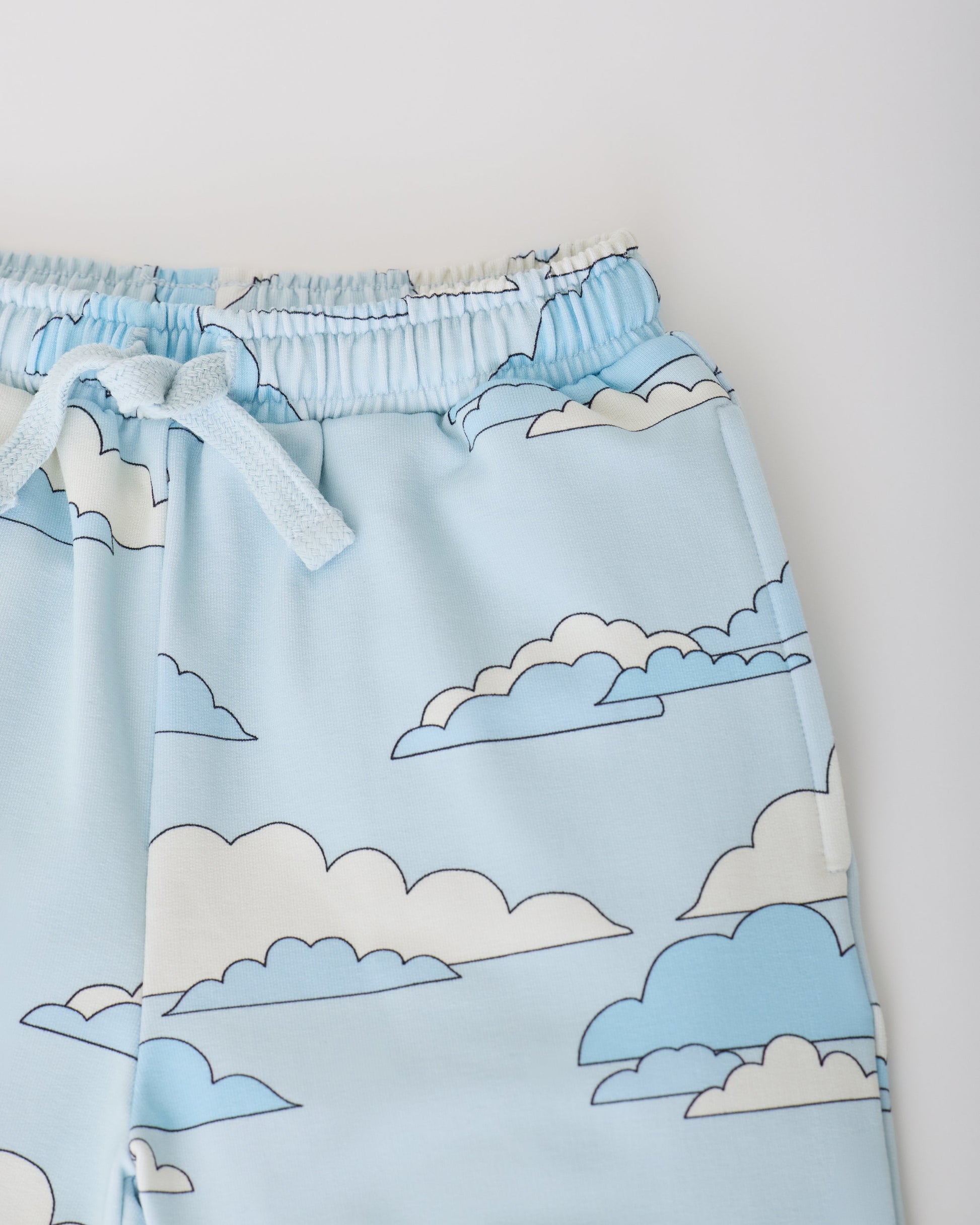 Close up of the waist band of the French Terry Jogger in Blue Clouds on a gray background.