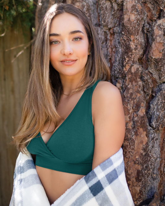 Front angled view of model outside wearing the French Terry Racerback Nursing & Sleep Bra in Evergreen with blanket wrapped around her@model_info:Natasha is wearing a Small.