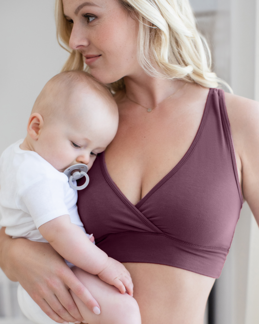 Front view of model wearing the French Terry Racerback Nursing & Sleep Bra in Burgundy Plum, and holding baby@model_info:Maddy is wearing a Small.