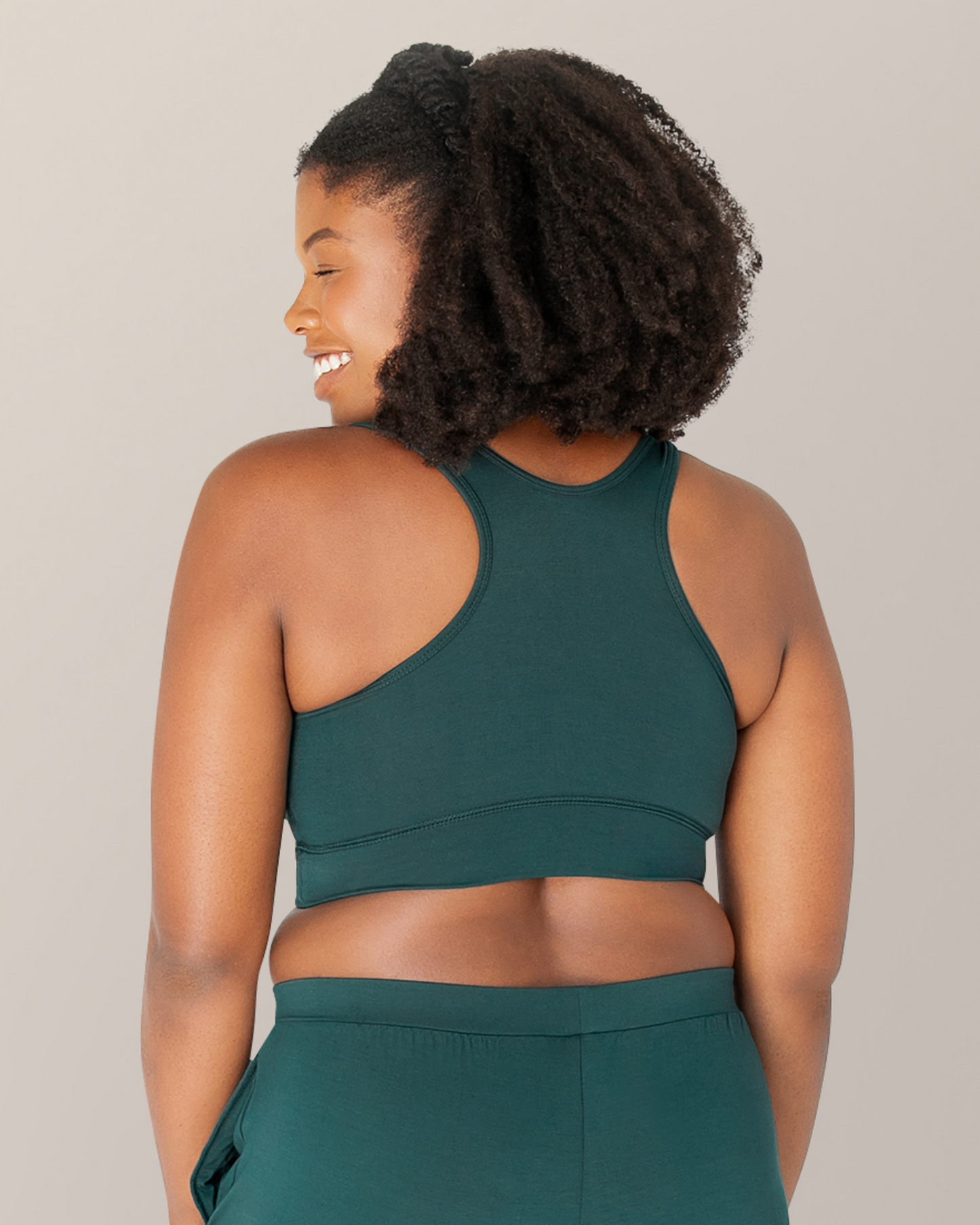 Back view of model outside wearing the French Terry Racerback Nursing & Sleep Bra in Evergreen