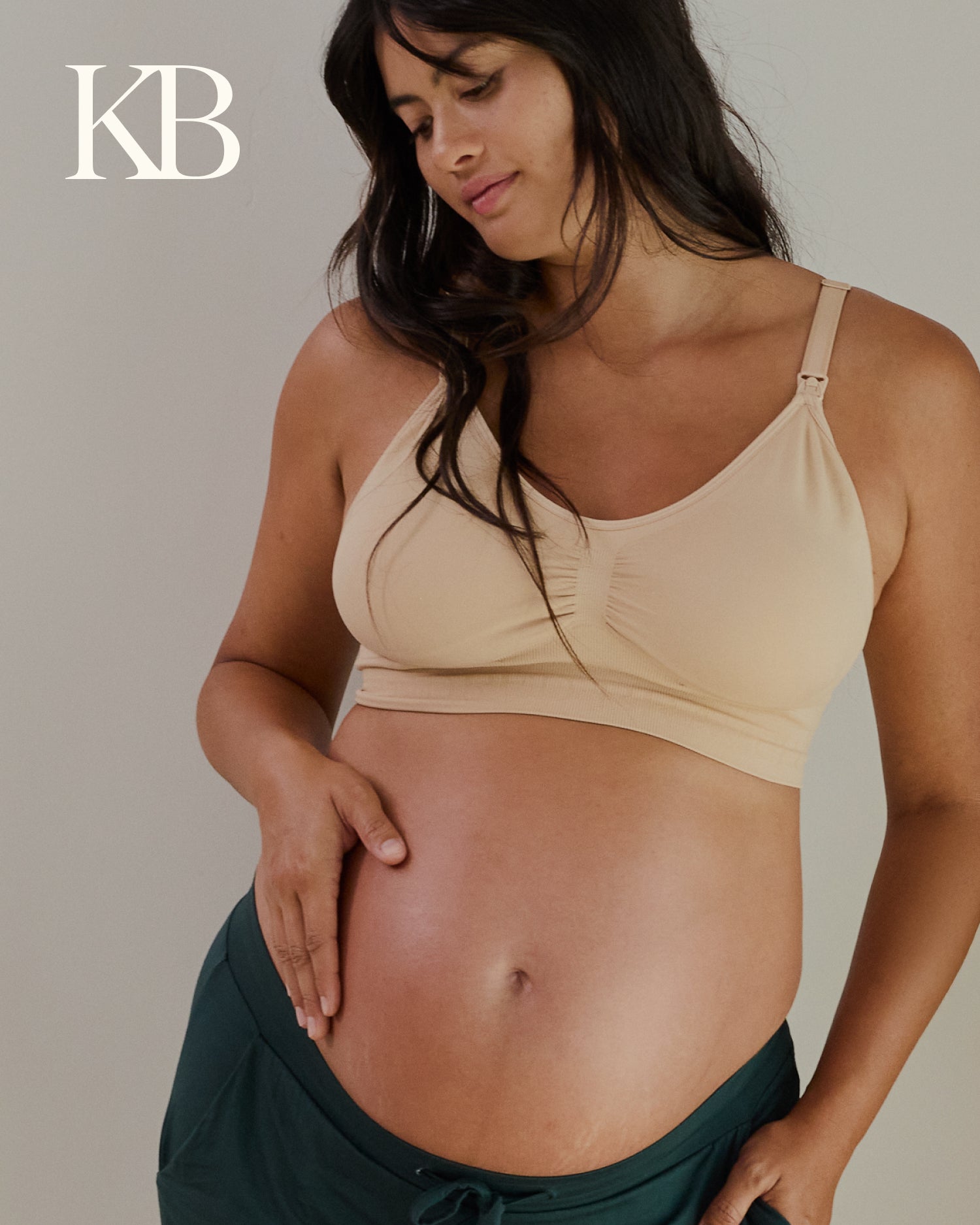 Pregnant woman wearing a beige maternity bra against a neutral background with 'KB' branding.