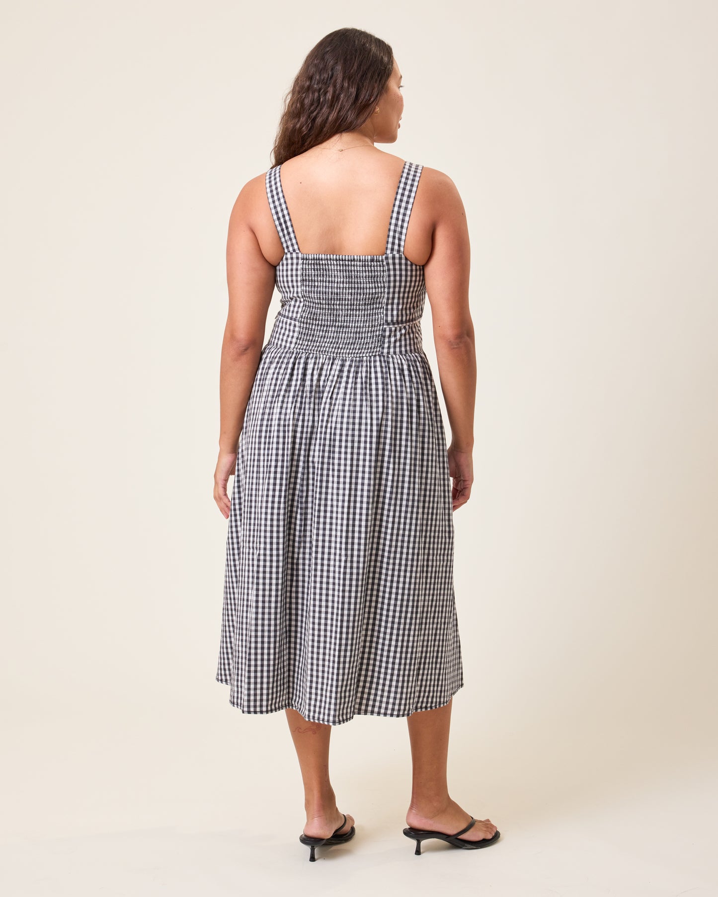 Back view of model wearing Gracie Poplin Nursing Midi Dress in Black & White Gingham 