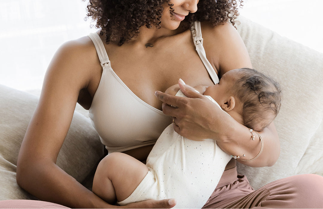 Woman wearing the Mia bra and nursing baby