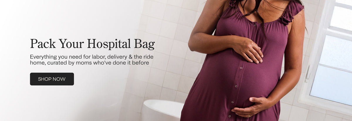 A pregnant woman in a Ruffle Labor & Delivery Gown stands in a bright bathroom, holding her baby bump. Text on the left reads 'Pack Your Hospital Bag' with a 'SHOP NOW' button, promoting hospital bag packing services curated by moms. Text reads, Everything you need for labor, delivery and the ride home, curated by moms who've done it before.