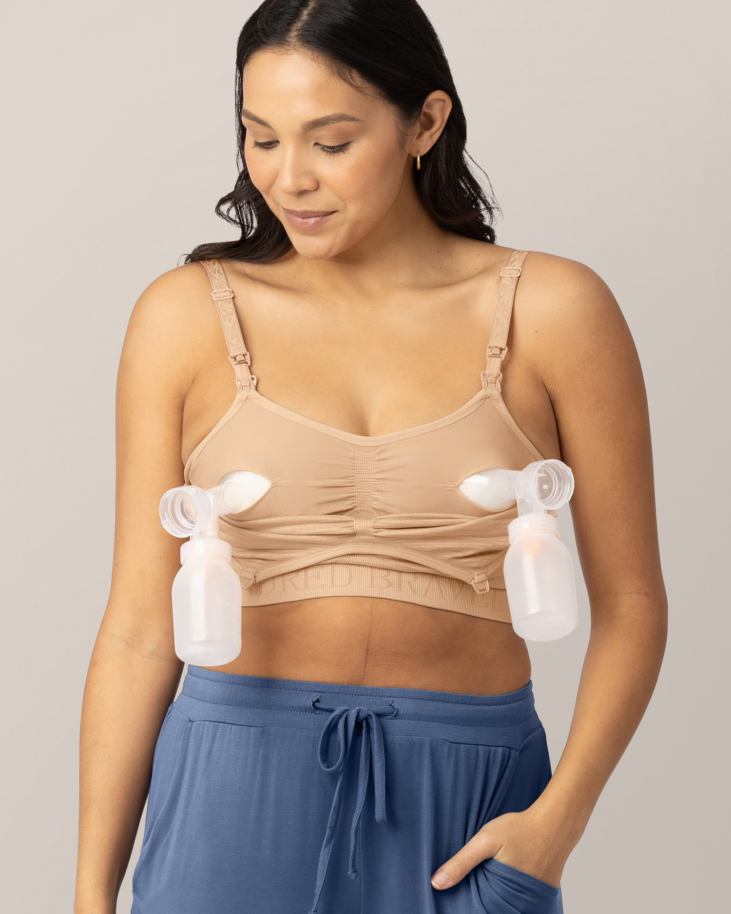 Woman wearing a beige bra with pump attachments on a plain background @model_info:Julana is wearing a Small.