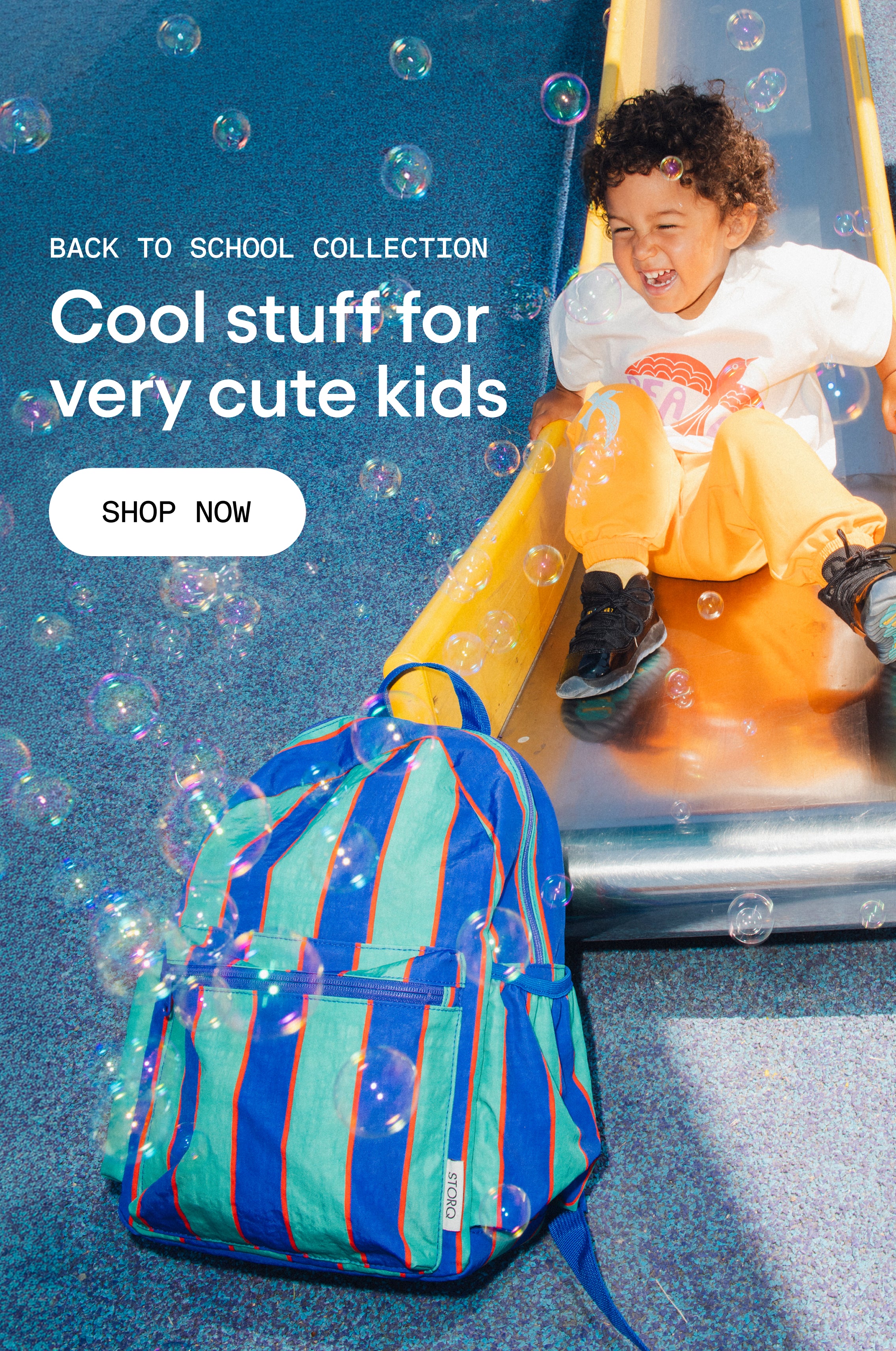 White text that reads: Back to School Collection, Cool stuff for very cute kids. White button with black text that reads: Shop Now. Image of child on slide with bubbles and Cool Kid Backpack in Navy & Green Stripe. 