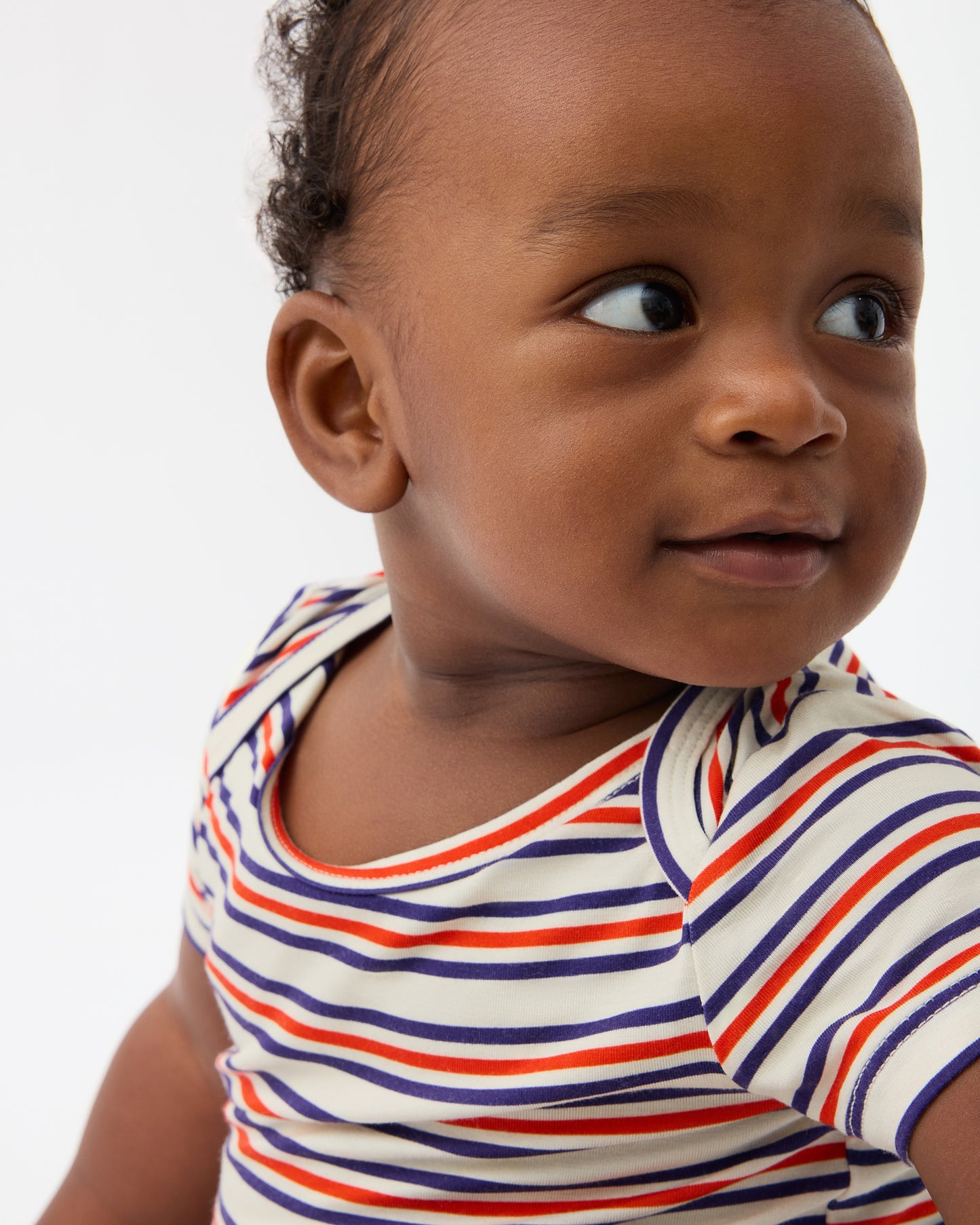 Baby is wearing Baby Onesie Two-Pack in Red & Blue Stripe on a beige background