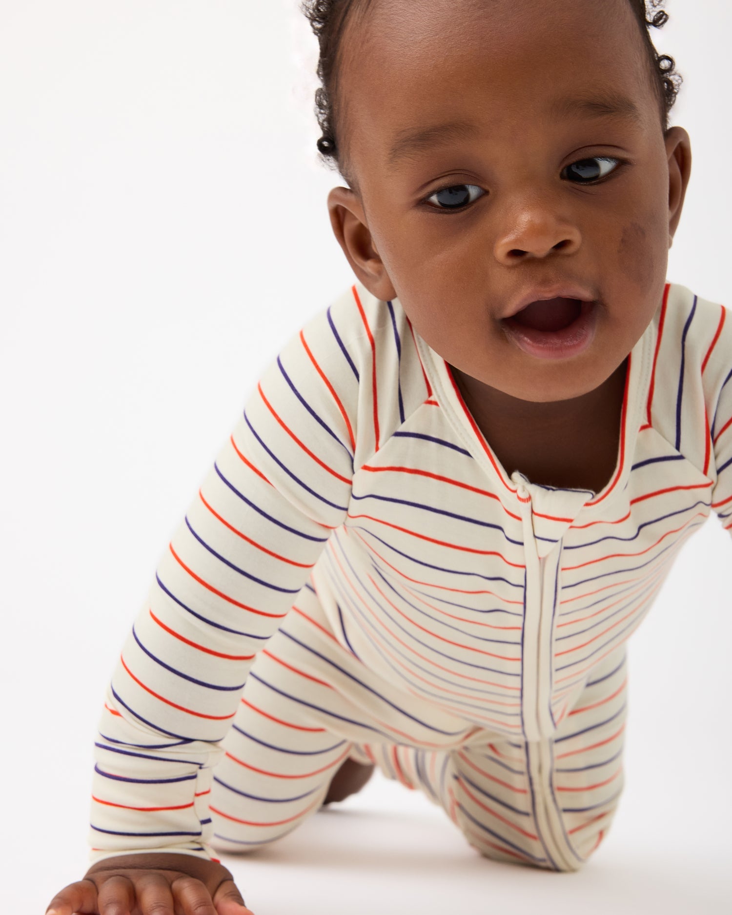 Baby is crawling and wearing Bamboo Baby Pajama in Pencil Stripe on a beige background