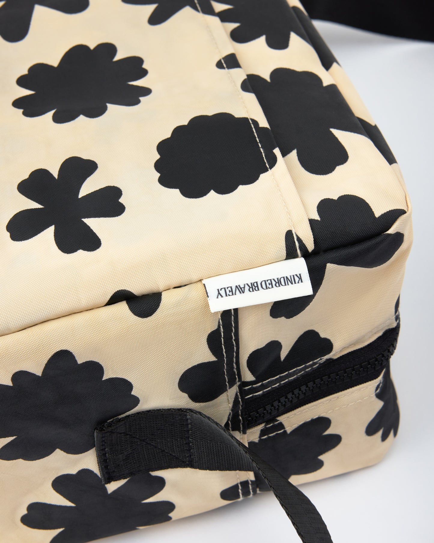 Close up of corner, tag and strap of Jumbo Cooler Bag in Cream Chamomiles on a beige background