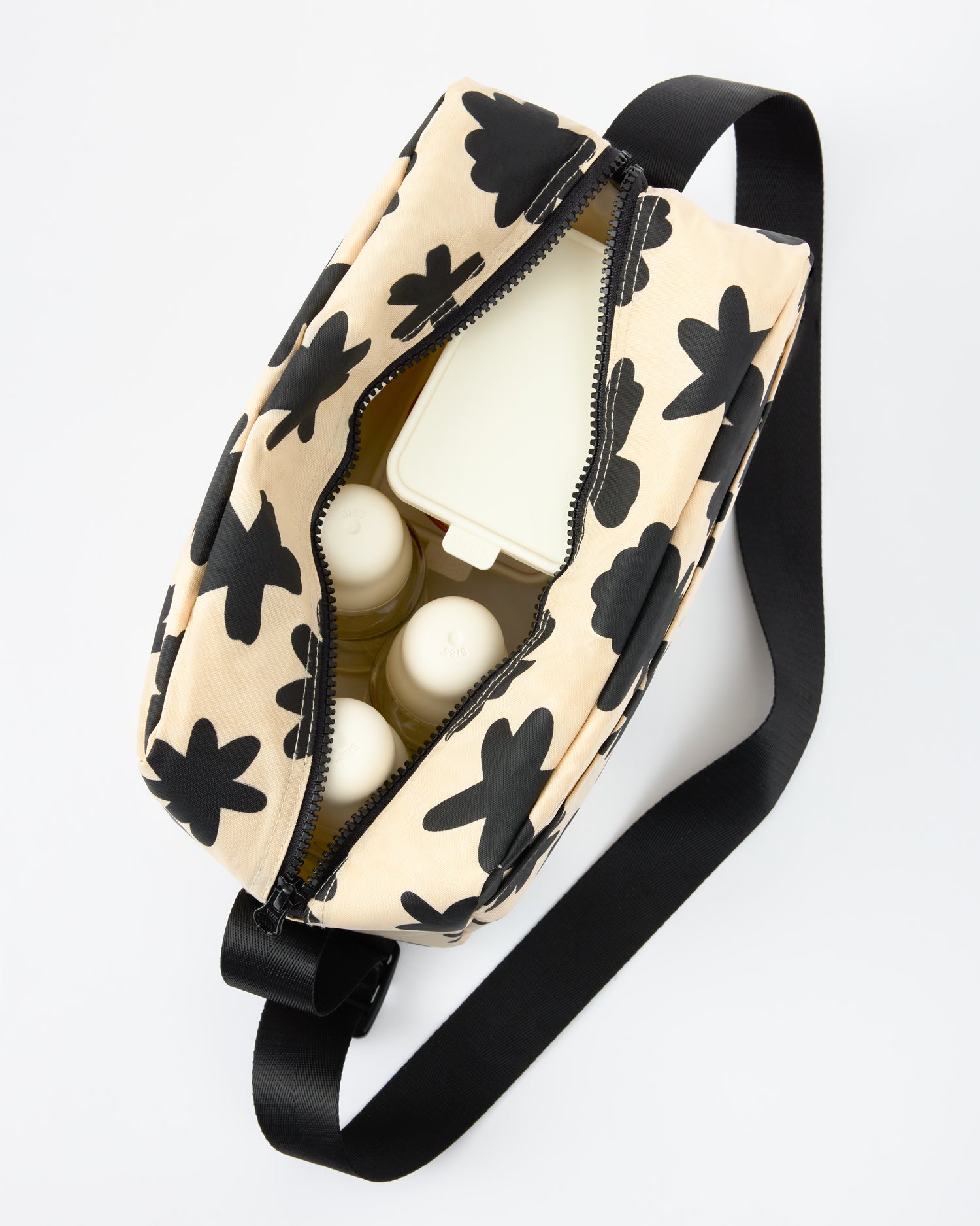 Peeking straight down into Jumbo Cooler Bag in Cream Chamomiles, packed with milk bottles and snack containers, on a beige background
