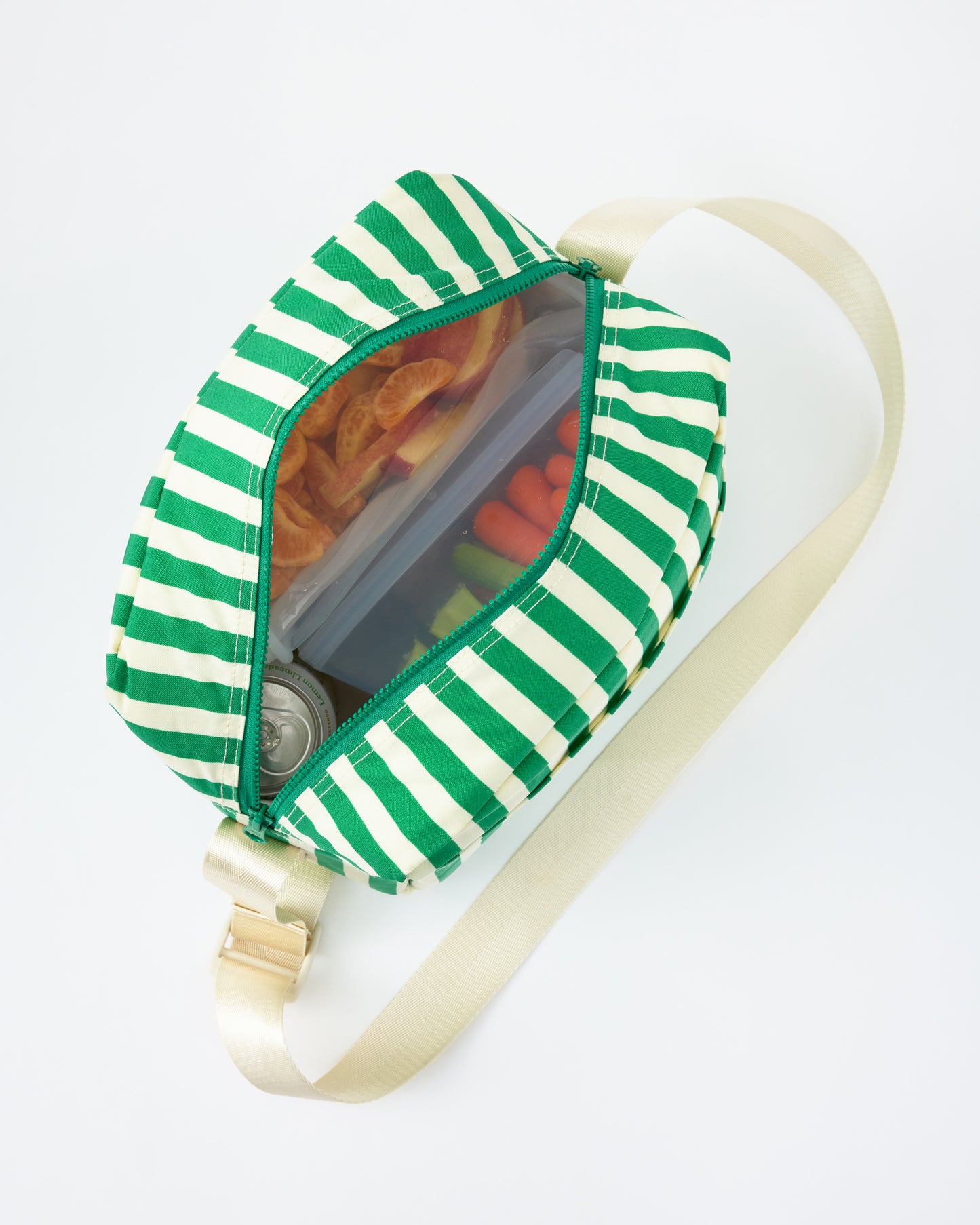 View looking down into Jumbo Cooler Bag in Green Stripe, filled with food and drinks, on a beige background.
