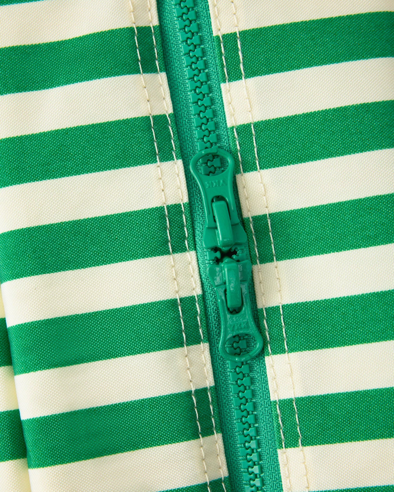 Close up of a closed zipper of the Jumbo Cooler Bag in Green Stripe.