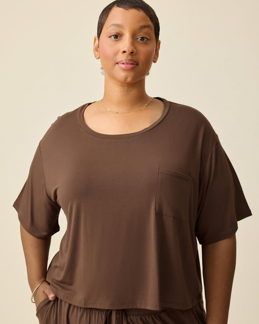 Model is wearing Aria Bamboo Casual Cropped Short Sleeve Top in Chocolate and Aria Bamboo Casual Lounge Pant in Chocolate, on a beige background. @model_info:Brittany is wearing an X-Large.