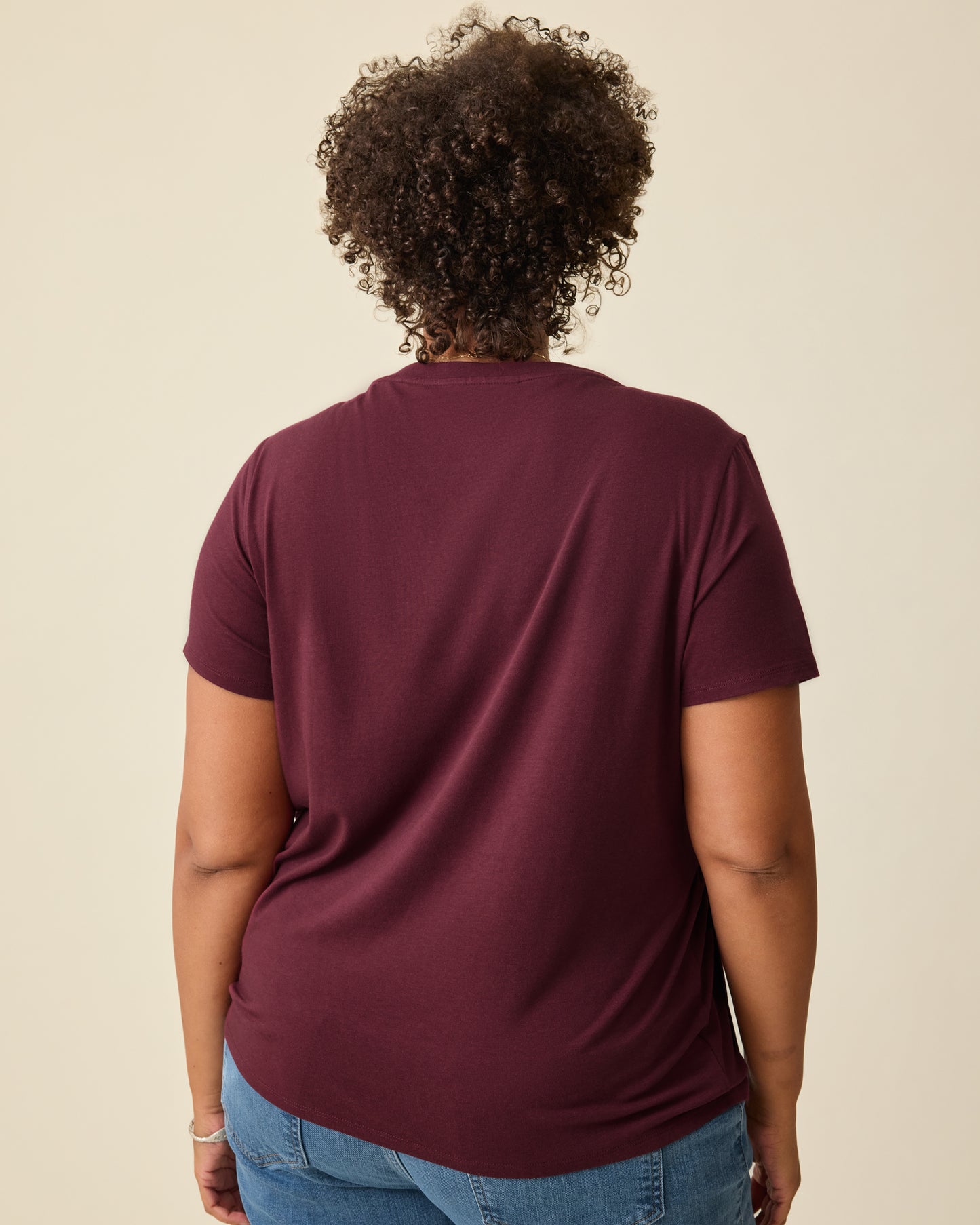 Back view of the Modal V-neck Nursing T-shirt in Deep Burgundy on a beige background. 