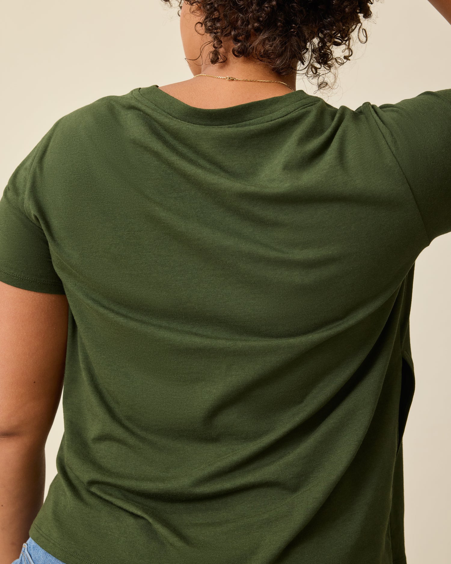 Back view of the Modal V-neck Nursing T-shirt in Deep Olive on a beige background.