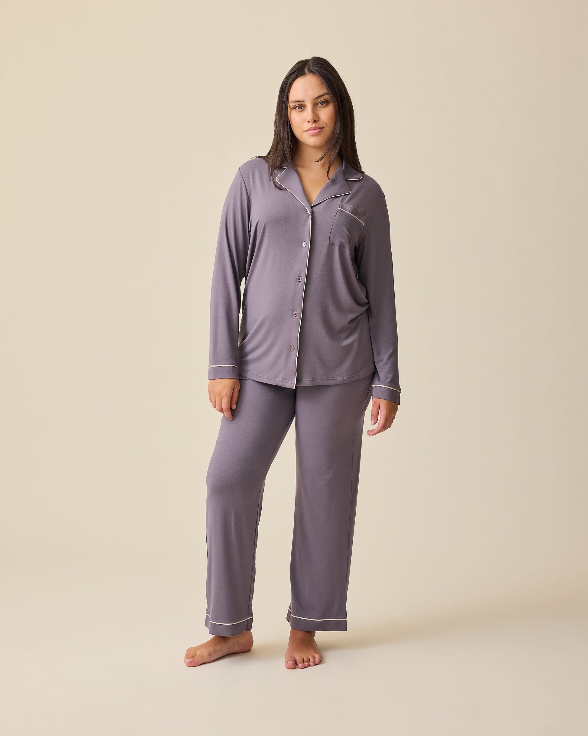 Model is wearing the Clea Bamboo Long Sleeve Pajama Set in Granite on a beige background. @model_info:Brianna is 5'8" and wearing a Medium.