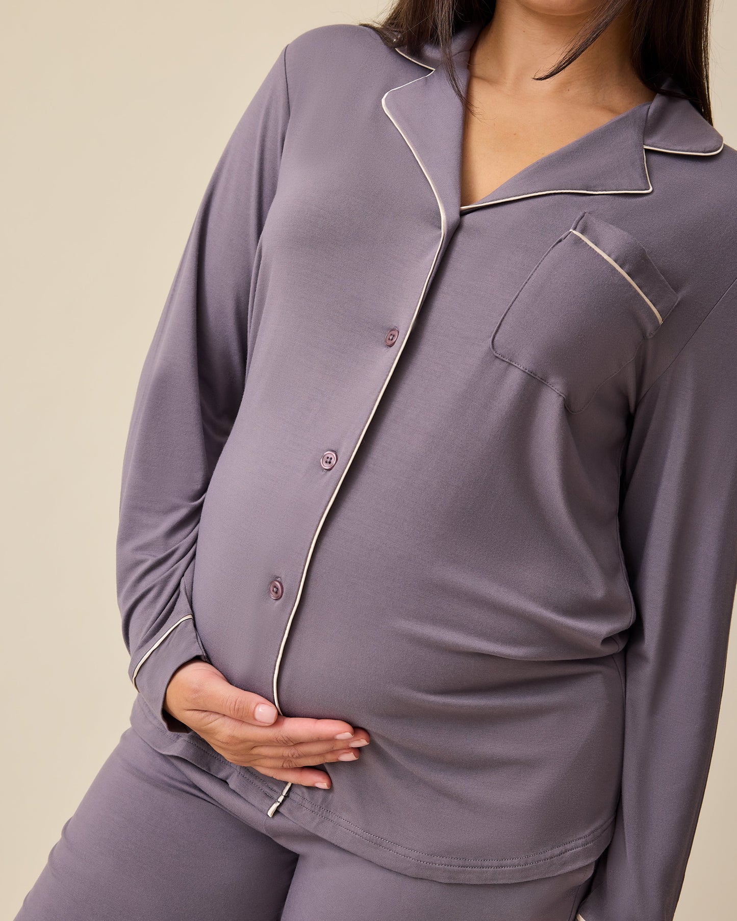 Angled view of model wearing the Clea Bamboo Long Sleeve Pajama Set in Granite on a beige background. 