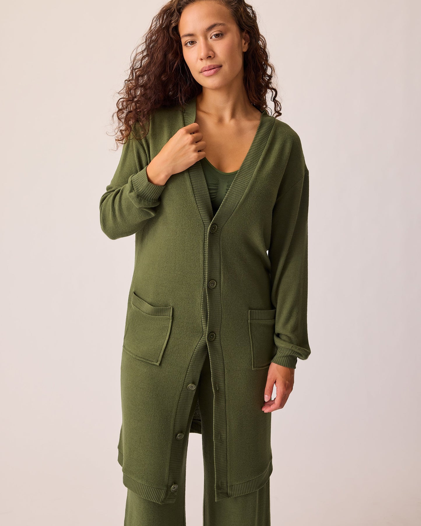 Model is wearing CozyKnit Long Cardigan in Deep Olive, with Simply Sublime® Nursing Bra in Deep Olive, and CozyKnit Wide Leg Lounge Pant in Deep Olive on a beige background. @model_info:Sadie is 5'8" and wearing a Small.