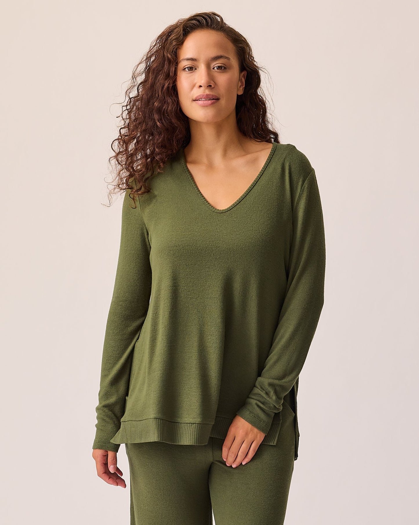 Model is wearing CozyKnit Maternity & Nursing V-neck Top in Deep Olive on a beige background. @model_info:Sadie is wearing a Small.