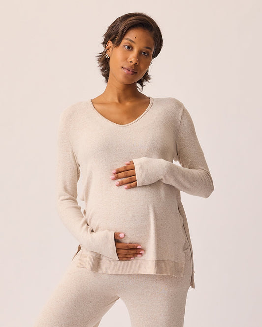 Model is wearing CozyKnit Maternity & Nursing V-neck Top in Oat and CozyKnit Wide Leg Lounge Pant in Oat on a beige background.
@model_info:Ale is wearing a Small.