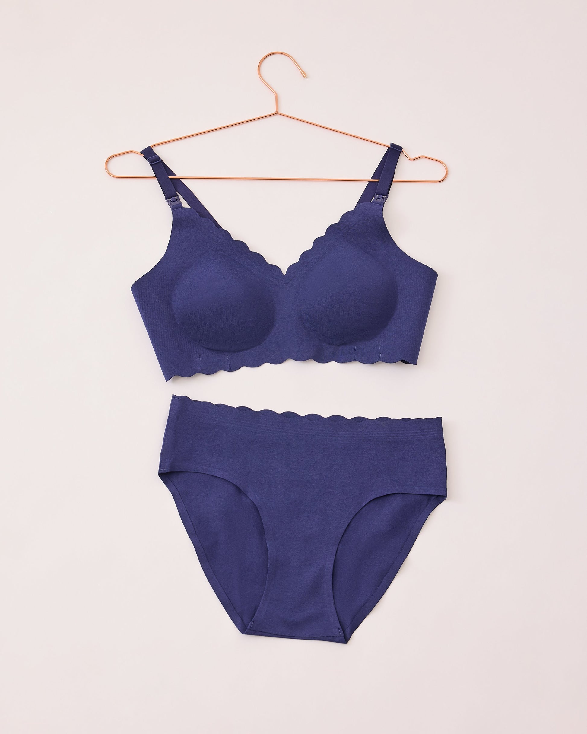 BareBond™ Cotton Maternity & Nursing Bra in Coastal Navy and BareBond™ Cotton Maternity & Postpartum Brief in Coastal Navy in flat lay on a hanger and beige background.