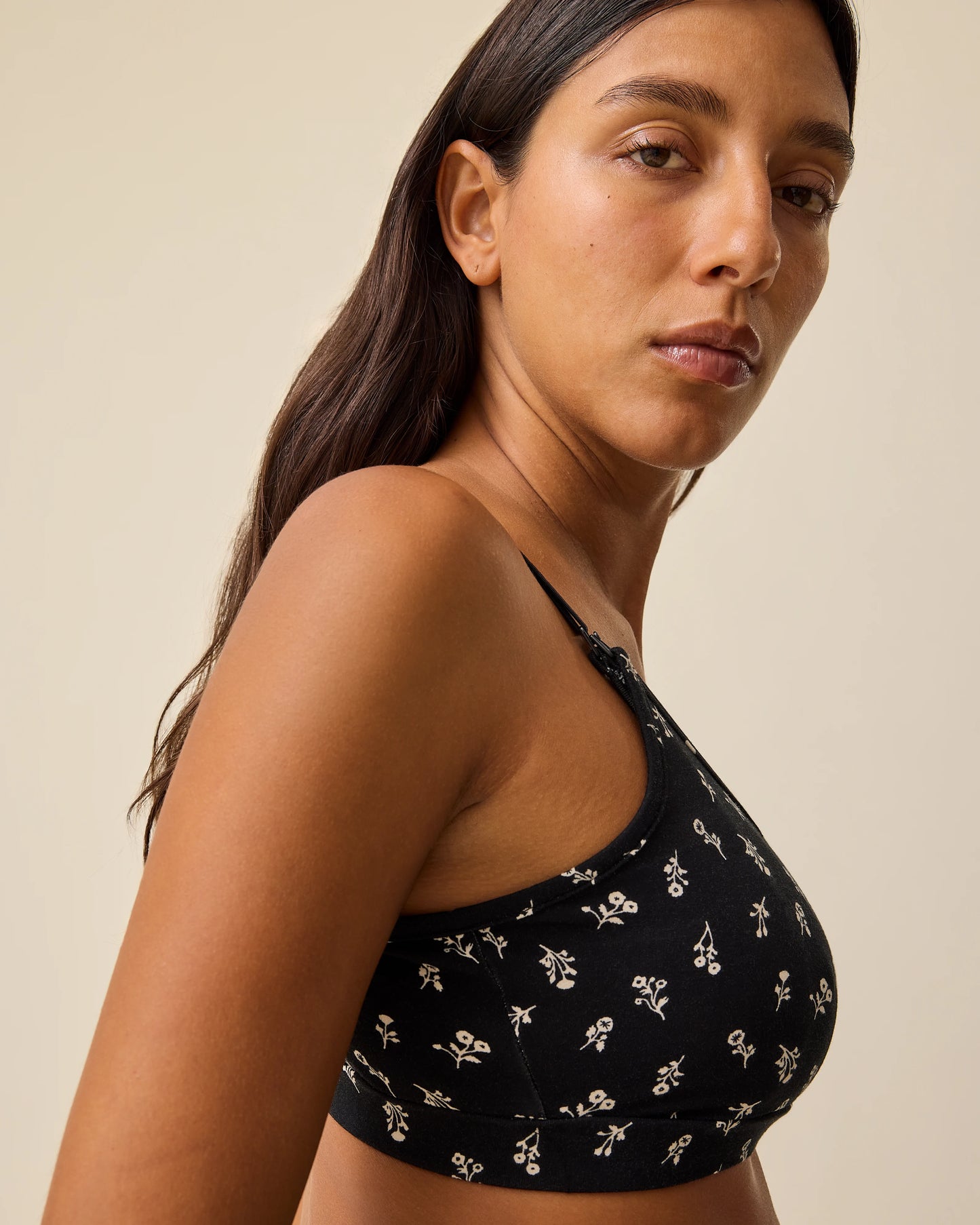 Side view of French Terry Maternity & Nursing Bralette in Black Wildflower on a beige background.