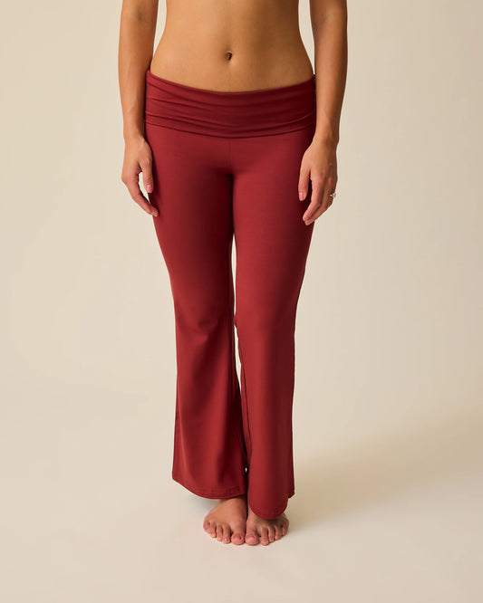 Model is wearing Bamboo Flex Maternity & Postpartum Flare Pant in Auburn on a beige background. @model_info:Sadie is 5'8" and wearing a Medium.