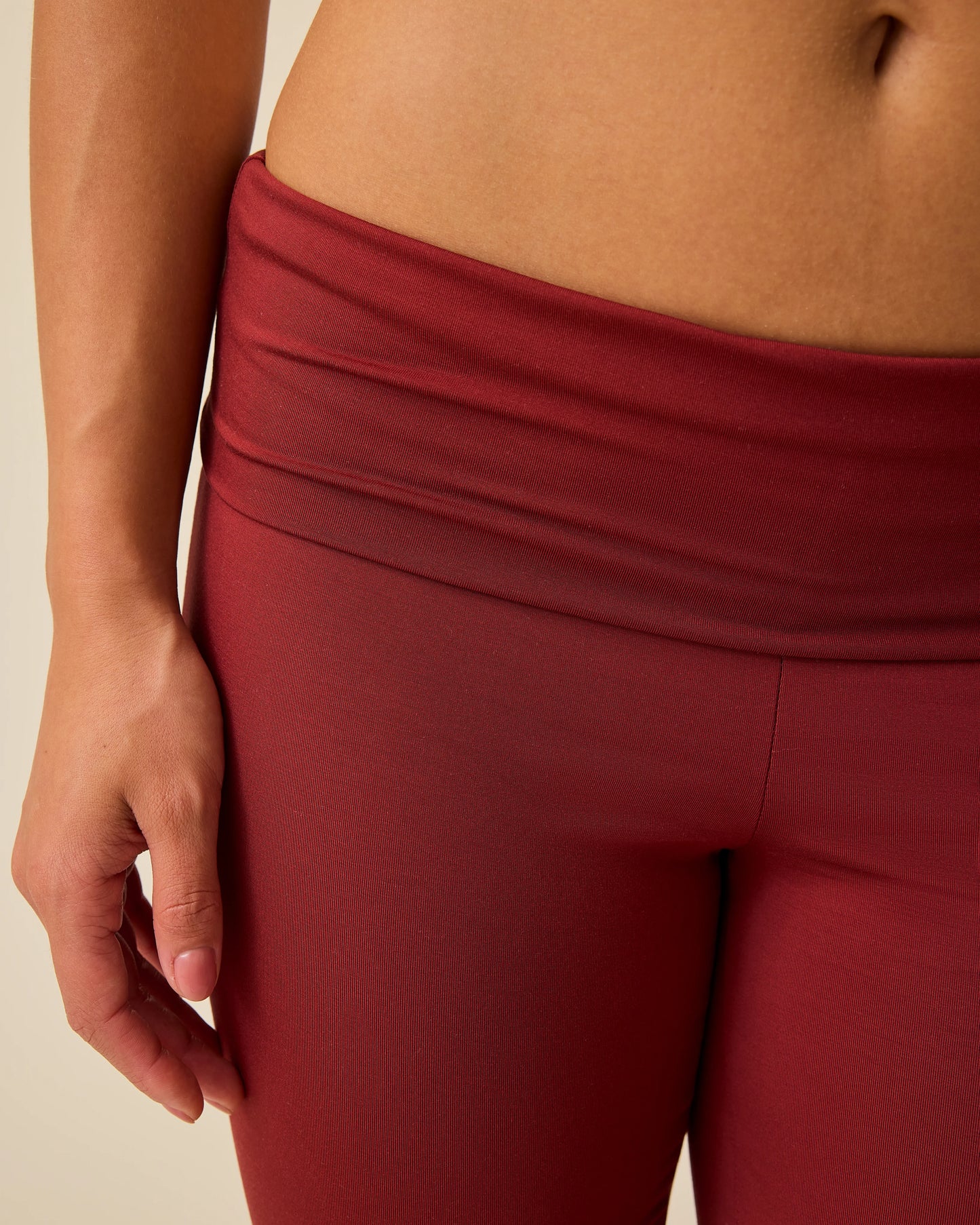 Close up of waist on the Bamboo Flex Maternity & Postpartum Flare Pant in Auburn on a beige background. 