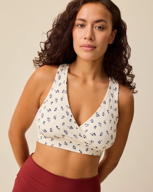 Model is wearing French Terry Racerback Nursing & Sleep Bra in Ivory Wildflower on a beige background. @model_info:Sadie is wearing a Small.