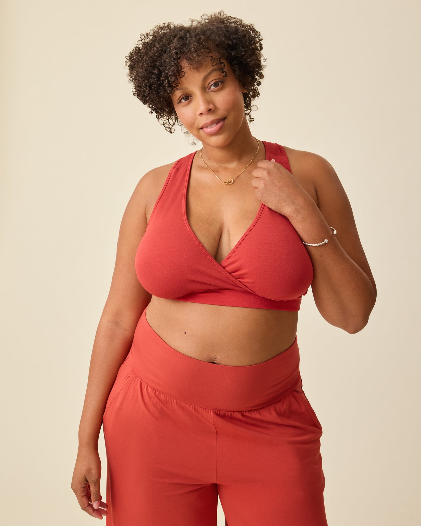 Model is wearing French Terry Racerback Nursing & Sleep Bra in Spice on a beige background