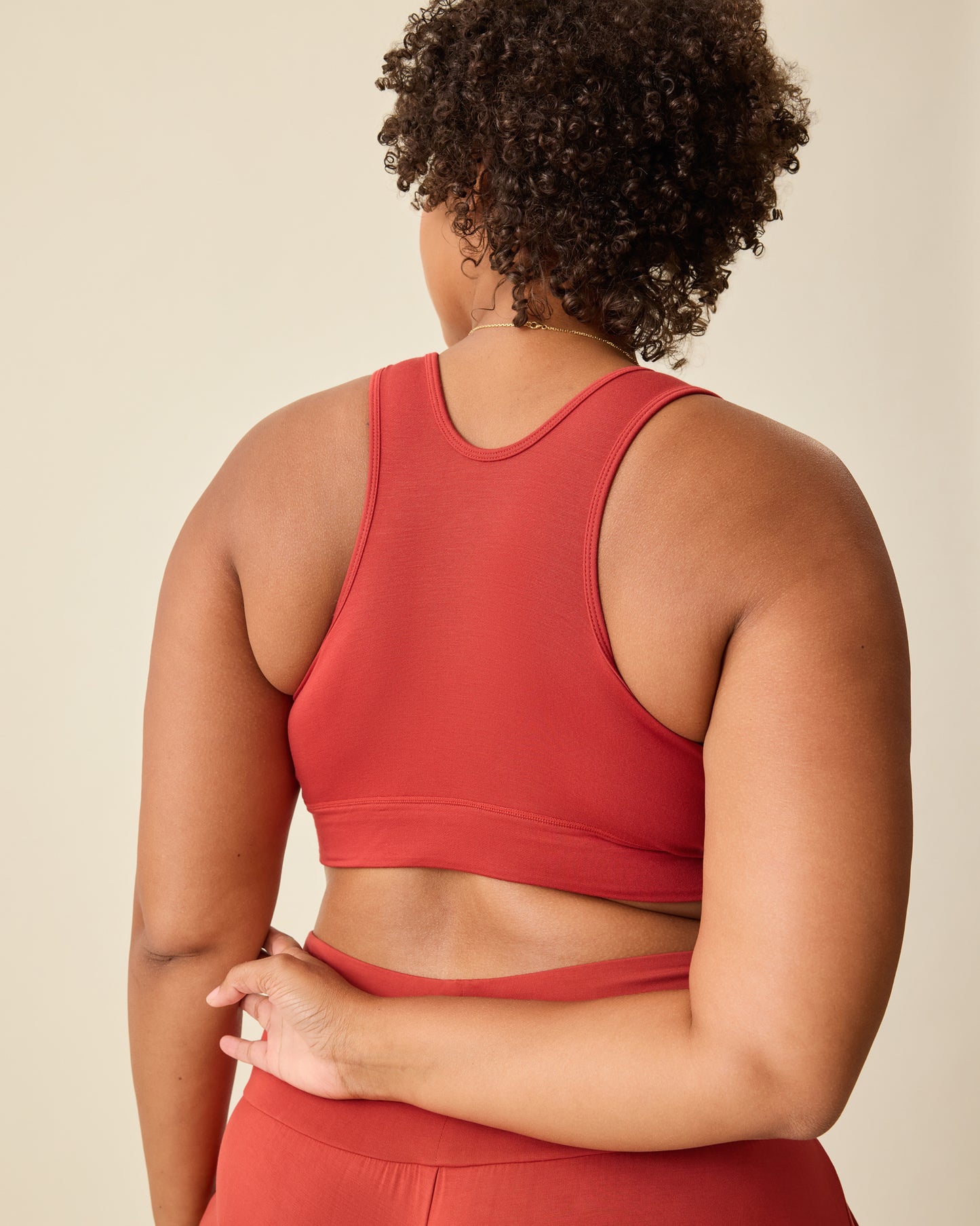 Back view of Model wearing French Terry Racerback Nursing & Sleep Bra in Spice on a beige background