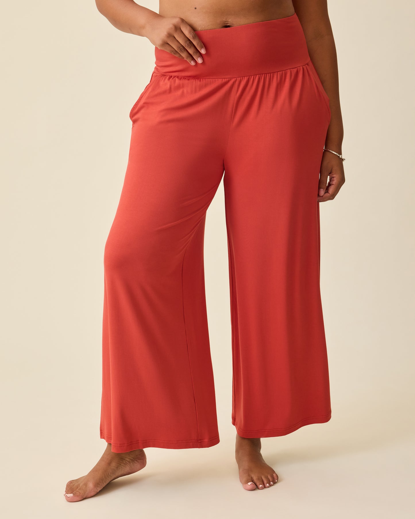 Model is wearing Bamboo Wide Leg Maternity & Postpartum Lounge Pant in Spice on a beige background.