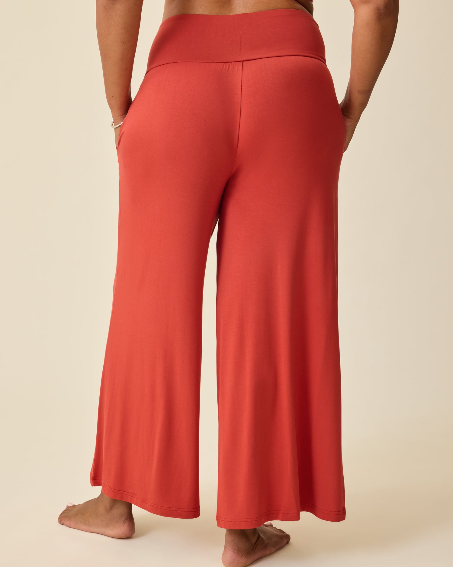 Back view of model wearing Bamboo Wide Leg Maternity & Postpartum Lounge Pant in Spice on a beige background.