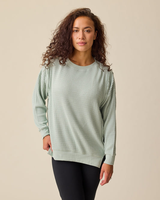 Model is wearing the Joelle Thermal Maternity & Nursing Top in Aqua Mist on a beige background. @model_info:Sadie is wearing a Medium.