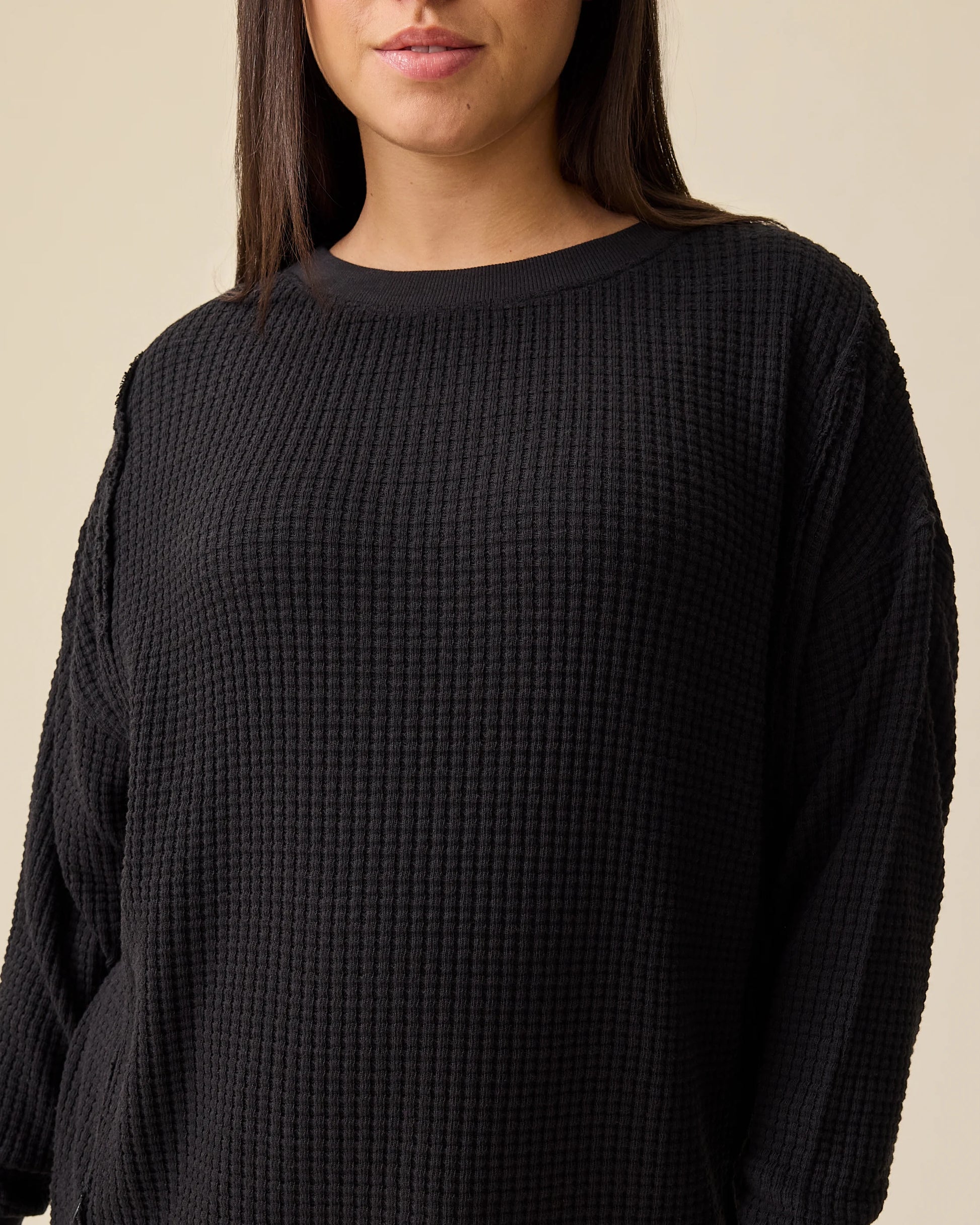 Model is wearing the Joelle Thermal Maternity & Nursing Top in Black on a beige background.