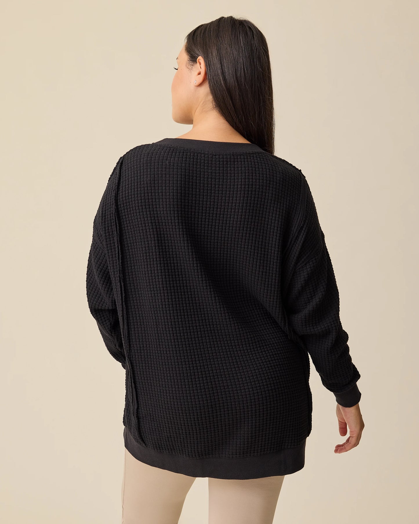 Back view of model wearing the Joelle Thermal Maternity & Nursing Top in Black on a beige background.