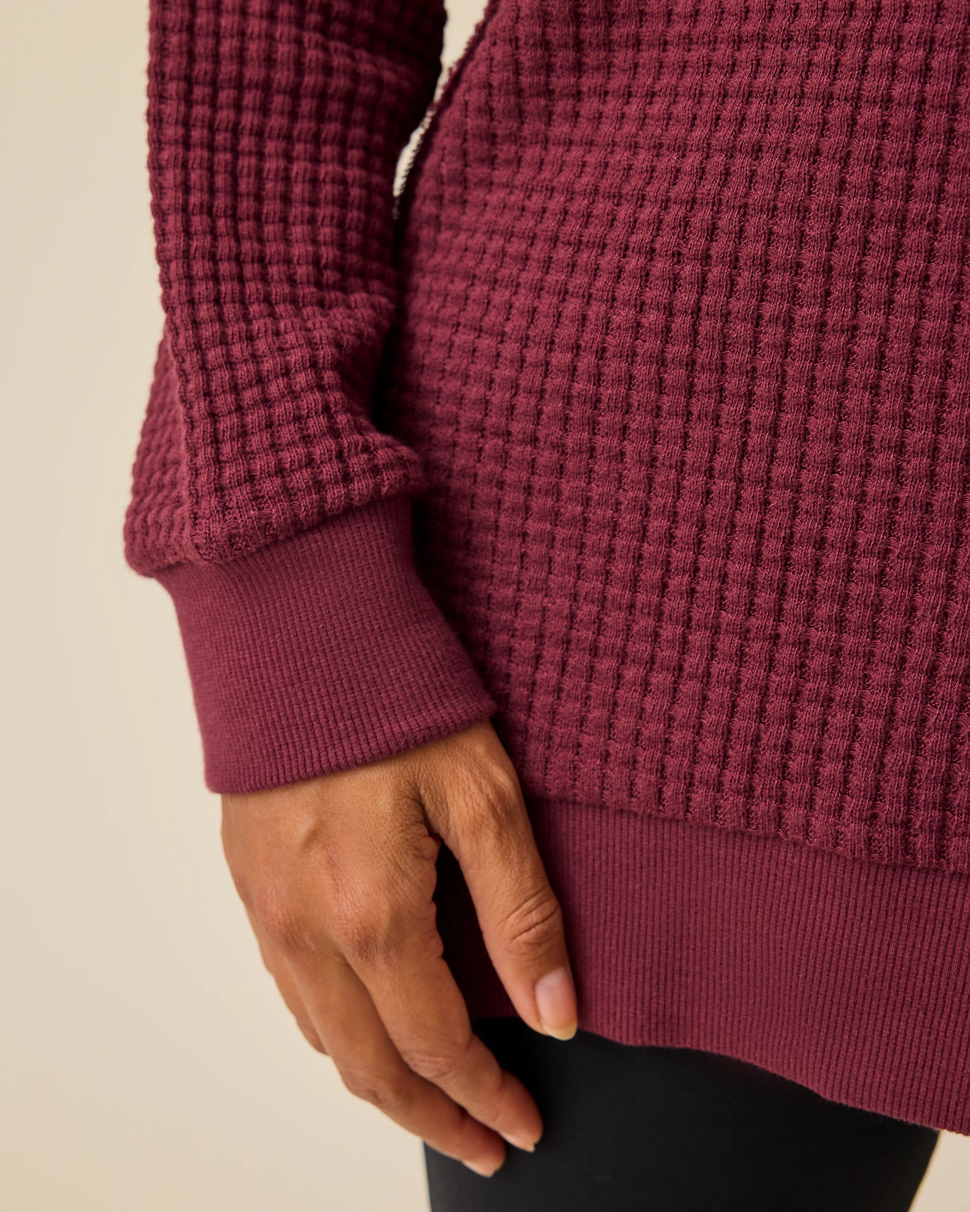 Close up of the detail on the Joelle Thermal Maternity & Nursing Top in Garnet with black pants on a beige background.